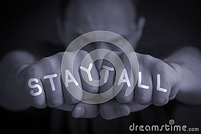 STAY TALL written on an angry manâ€™s fists Stock Photo